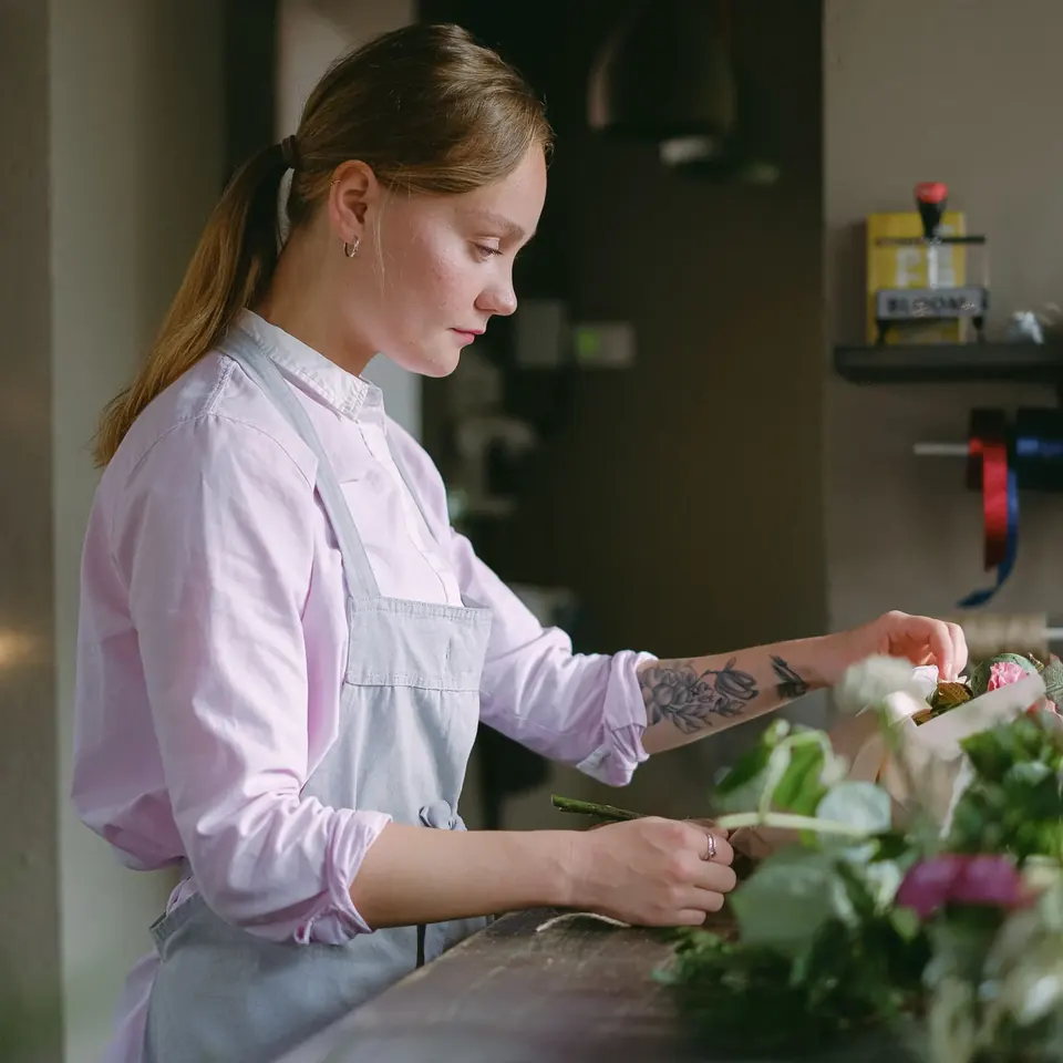 Floristin bindet in ihrem Blumenladen einen Strauß aus frischen Blumen