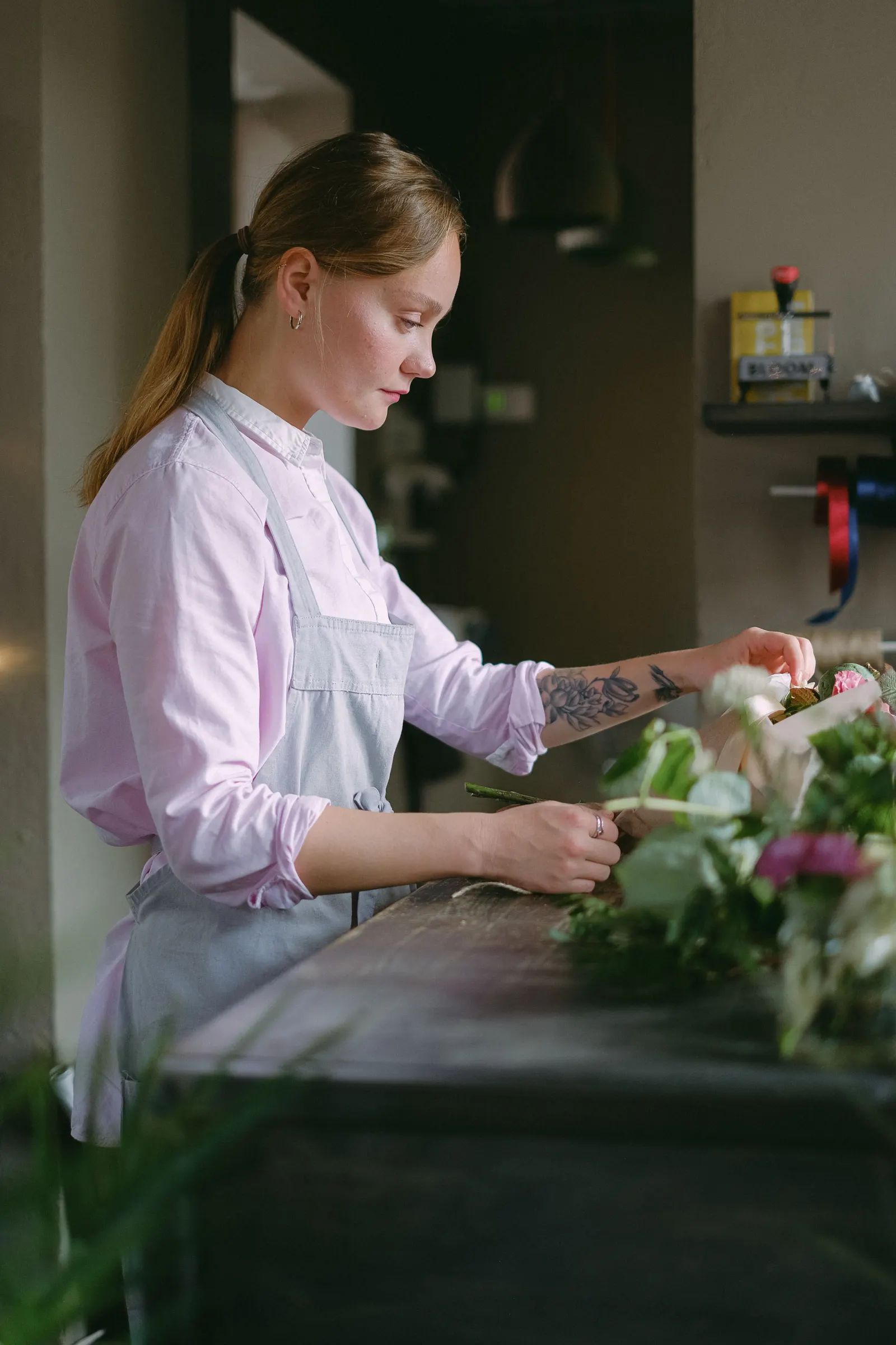 Floristin arrangiert ein farbenfrohes Blumensortiment für Kundinnen und Kunden