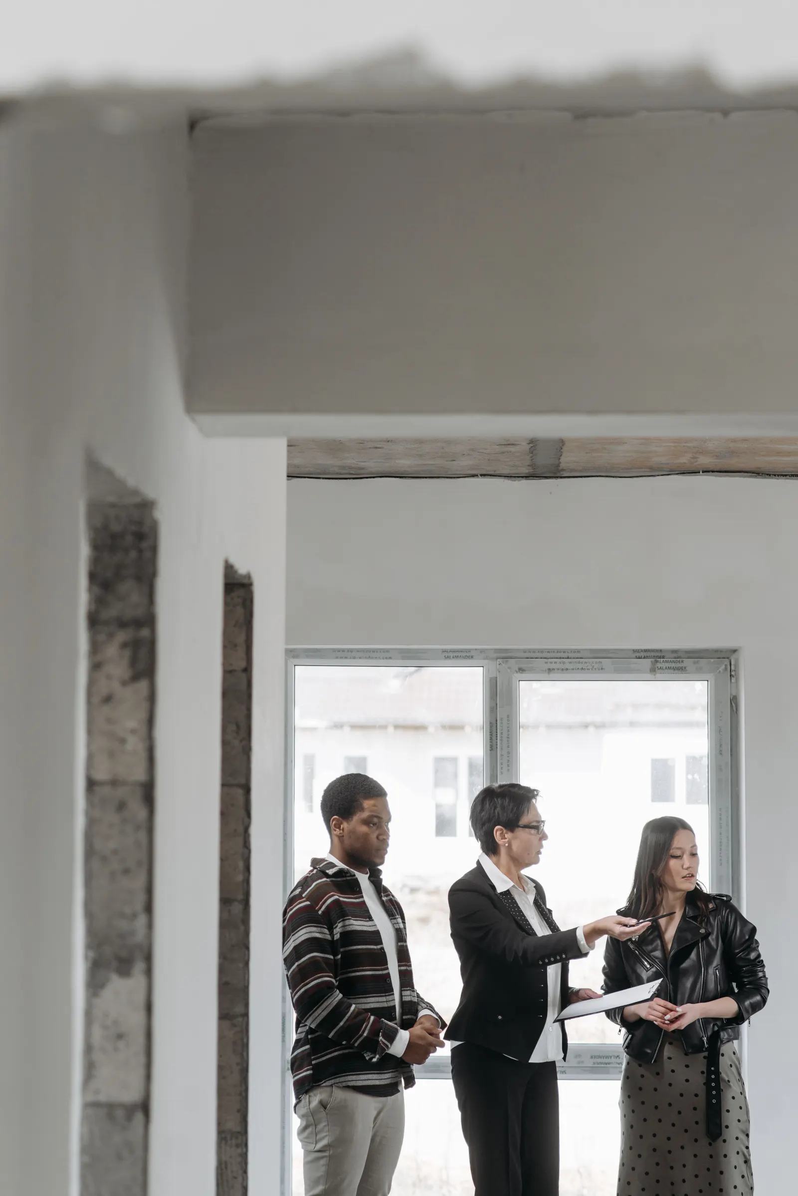 Immobilienberater bespricht mit einem Paar Unterlagen zu einer Immobilie
